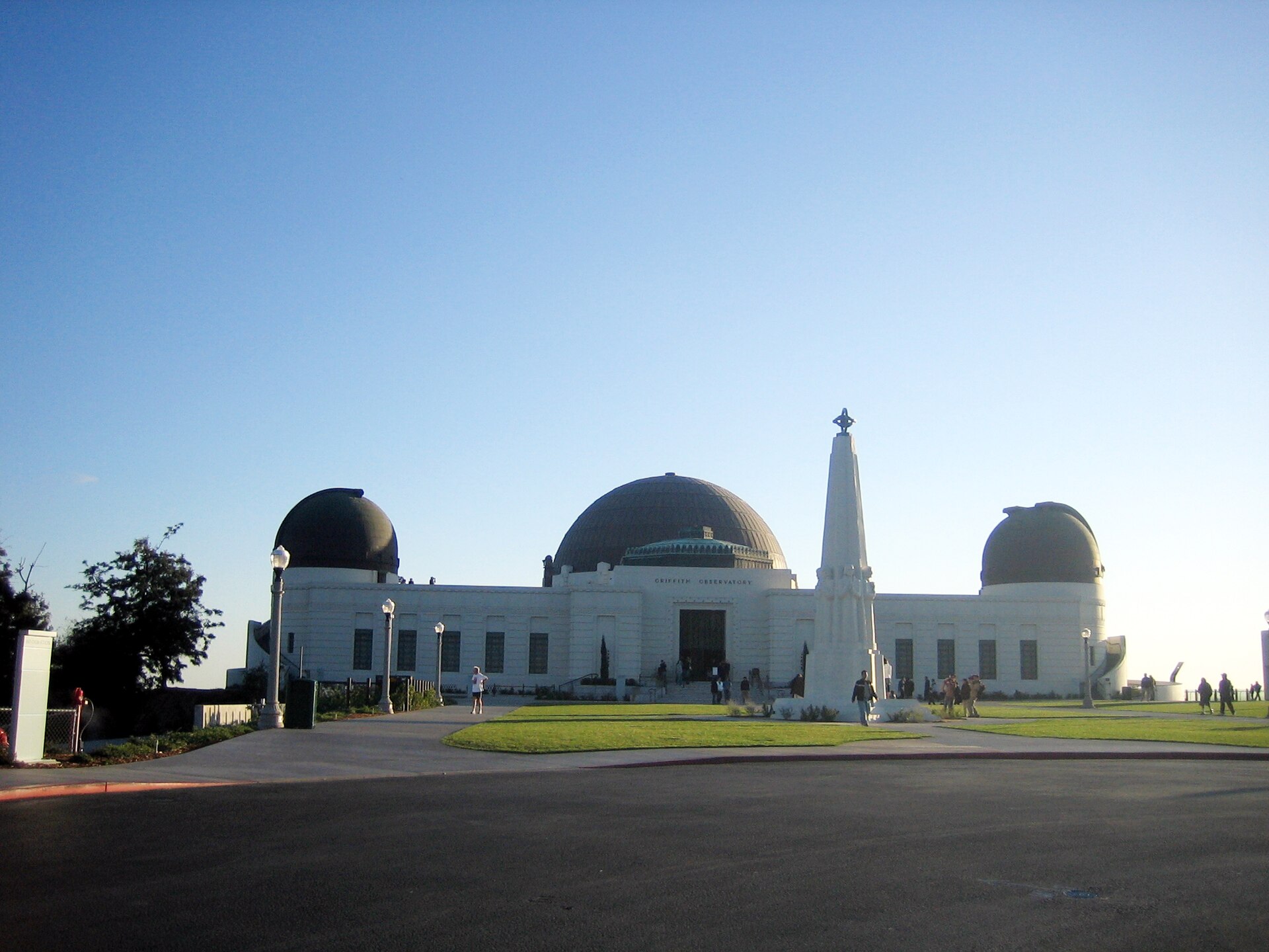 Griffith Observatory under a wide Los Angeles sky, white domes and lawn at dusk light